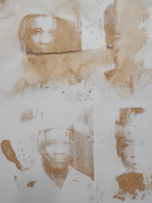 Impressions en mélasse brune de portraits sur une surface blanche.